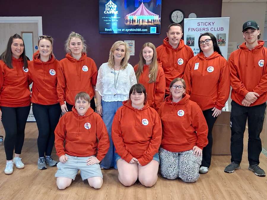 Sticky Fingers Club team wearing printed orange hoodies