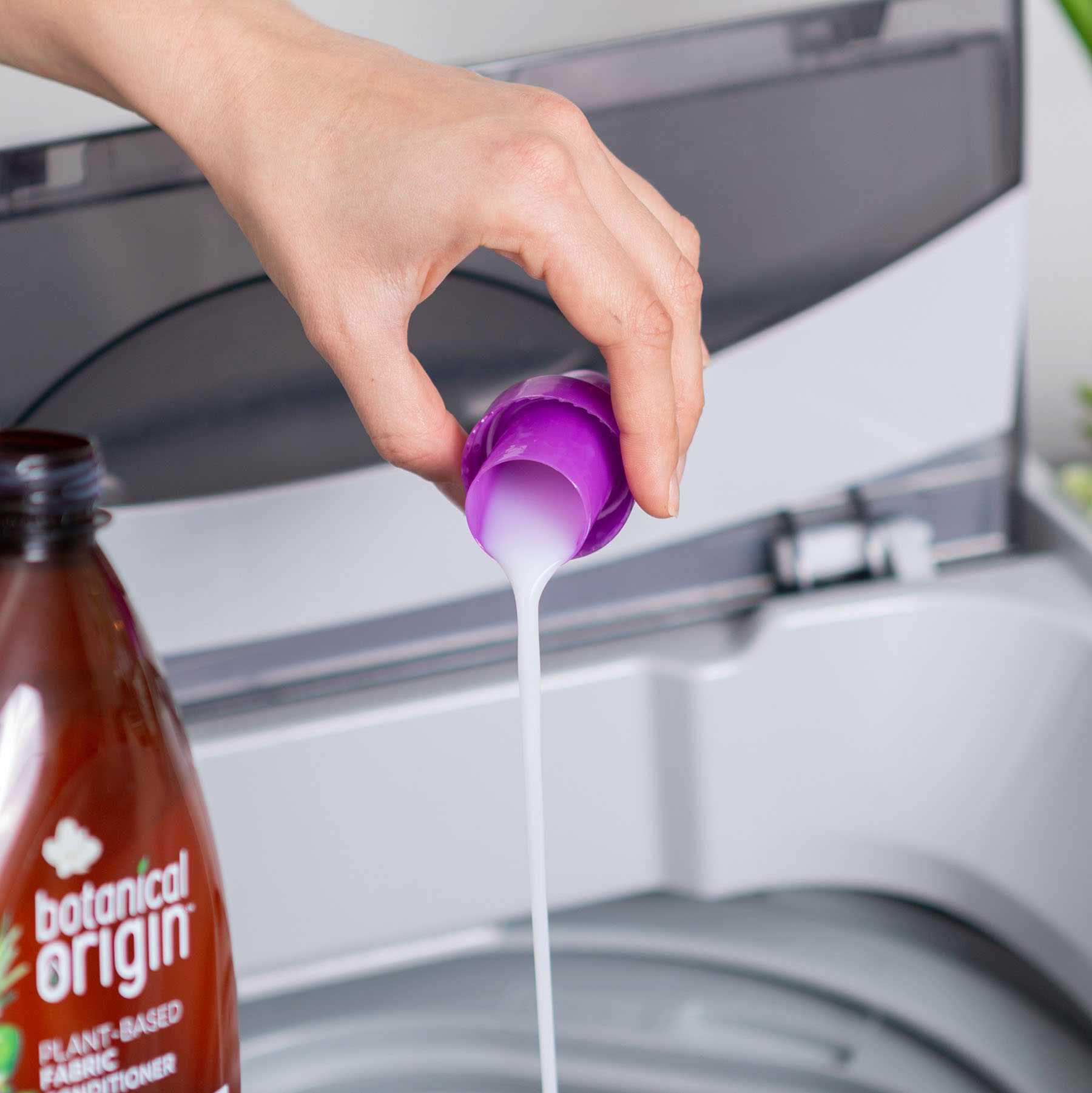 pouring fabric conditioner in to a washing machine